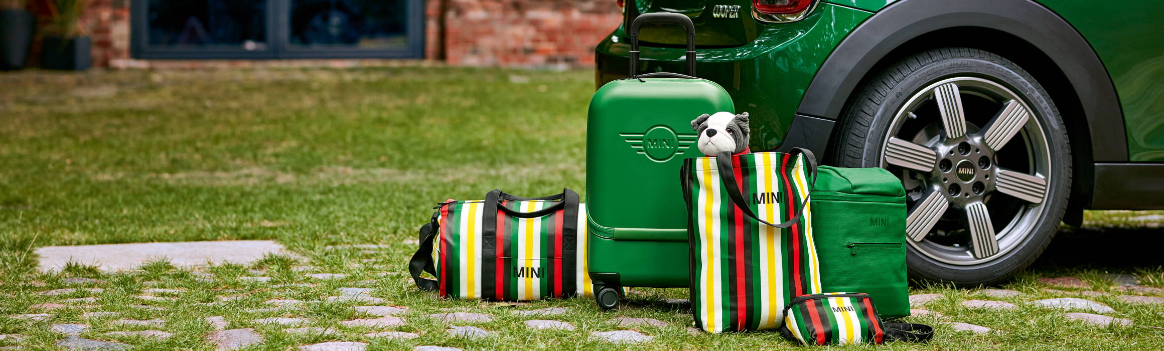 Koffer und Taschen im MINI-Design vor grünem MINI-Modell