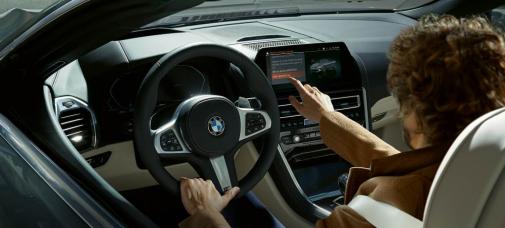 Mann bedient Multi-Info-Display in einem BMW 8er Cabrio