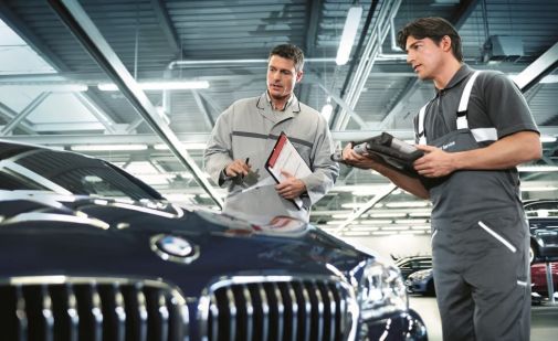 KFZ-Mecahtroniker und Kundendienstleiter prüfen einen BMW