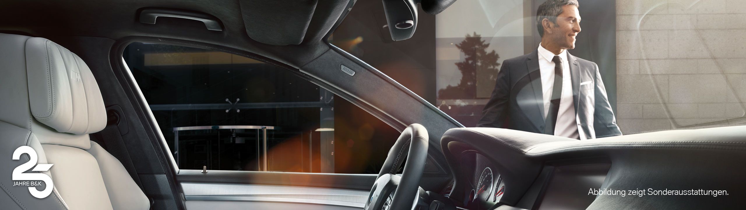 Foto vom Cockpit eines BMW - durch die Frontscheibe sieht man einen Geschäftsmann